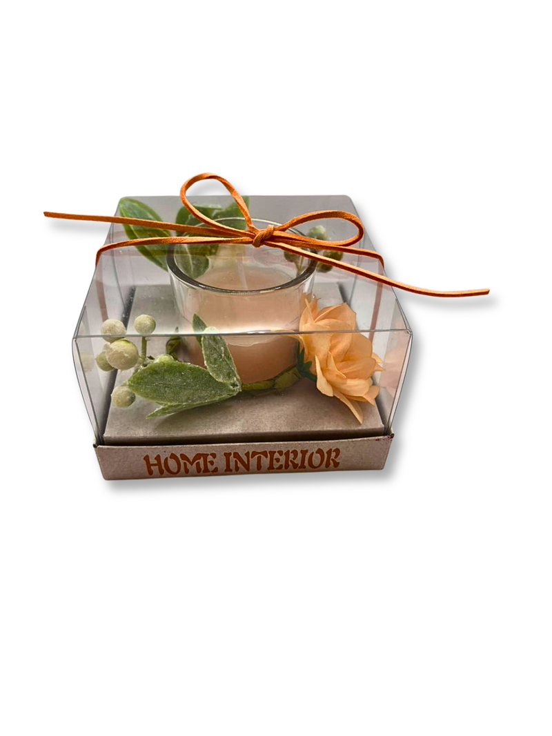 lumanare decorativa in pahar cu decor floral peach, frunze pastel si bobite albe, ambalata in cutie transparenta cu funda portocalie